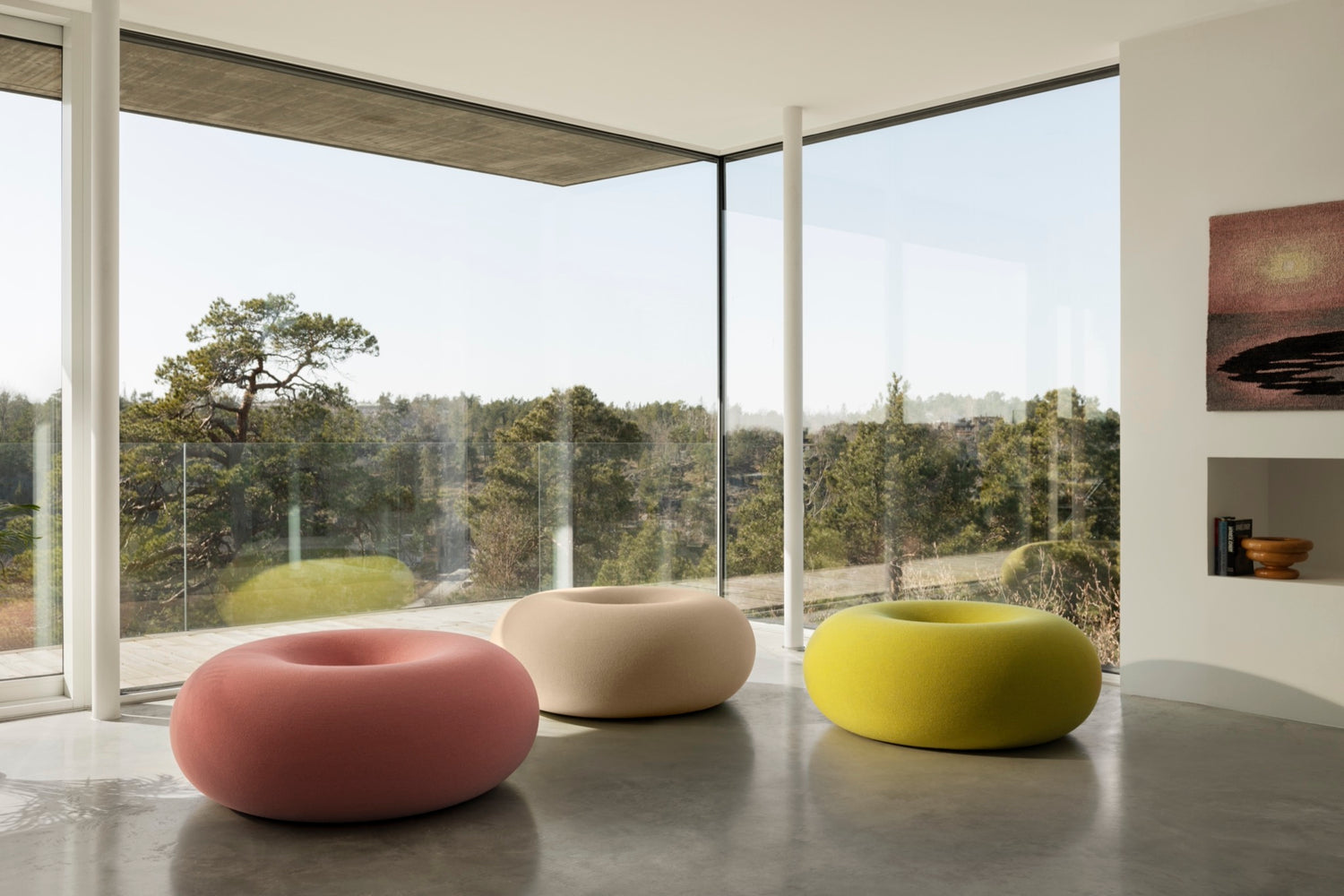 3 Boa Poufs in Cotton Candy, Oatmeal, and Sulfur sit on a grey floor.